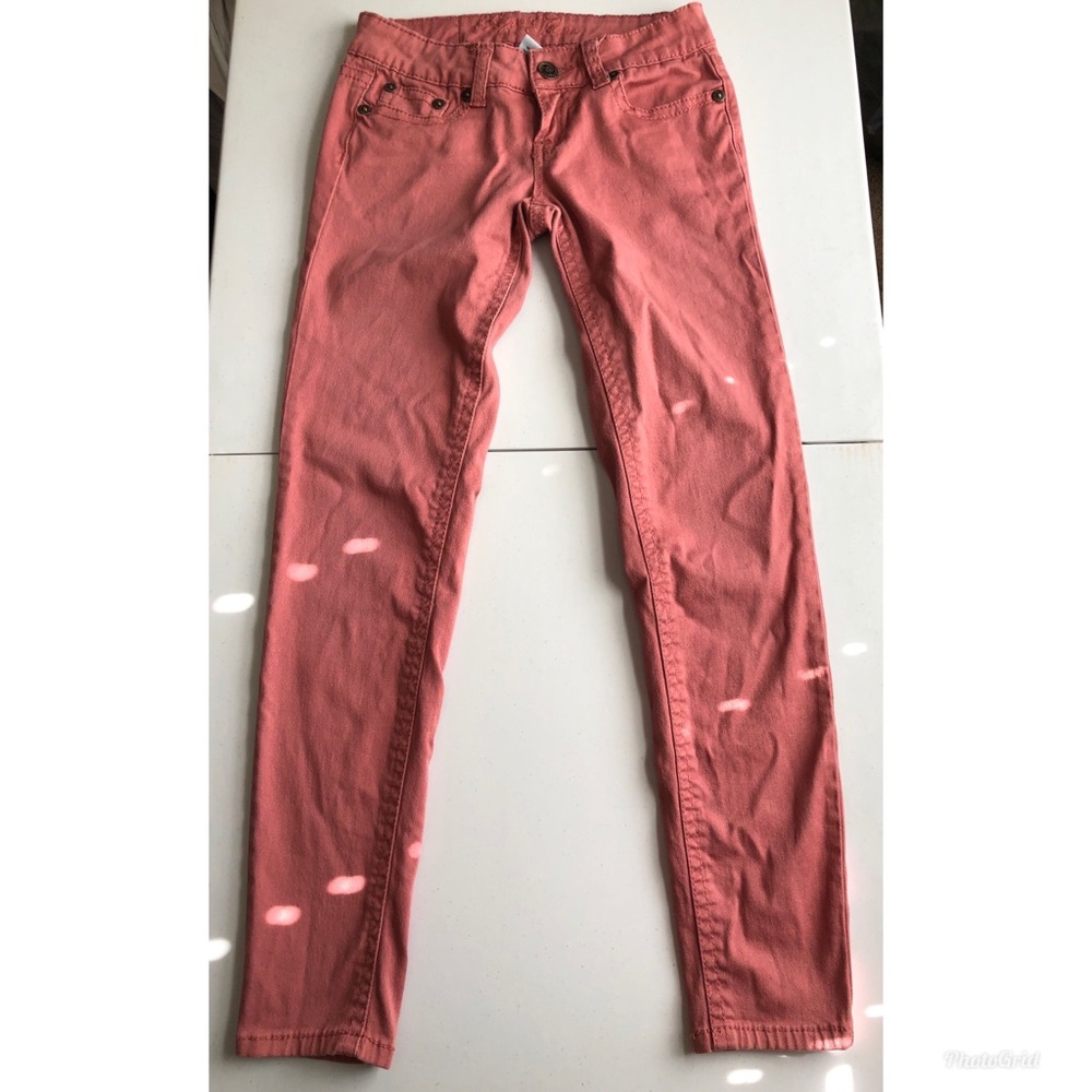 Salmon pink colored jeans.